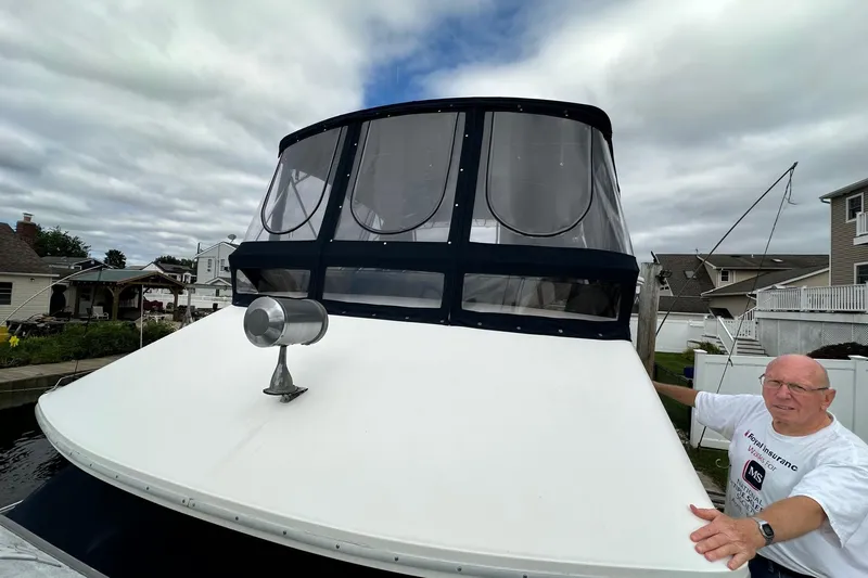 Slide: The Image of 1989 Sea Ray 380 Aft Cabin boat with a person standing beside it, docked in a residential area. - 31
