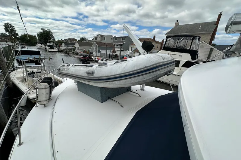 Slide: The Image of 1989 Sea Ray 380 Aft Cabin with inflatable boat on deck, docked in marina. - 35