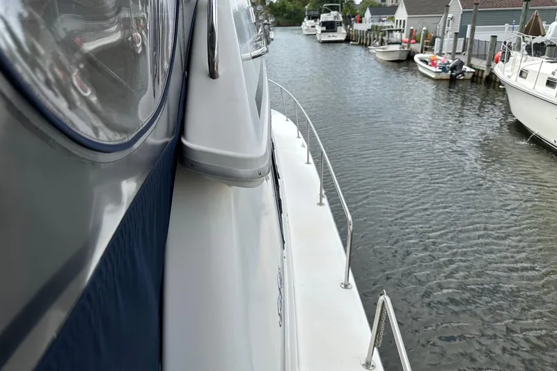 Slide: The Image of 1989 Sea Ray 380 Aft Cabin yacht docked in a serene marina setting. - 7