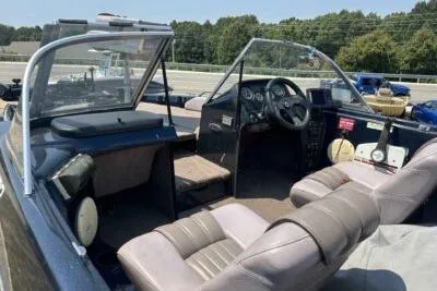 Slide: The Image of 1998 ProCraft 180 Combo boat interior with seating and dashboard, parked outdoors. - 3
