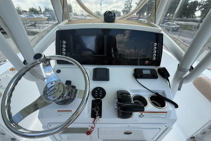 Slide: The Image of 2019 Sportsman 232 OE boat dashboard with steering wheel, controls, and navigation display. - 15