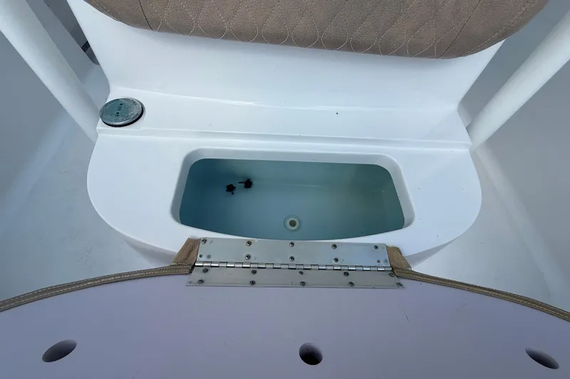 Slide: The Image of Livewell compartment on a 2019 Sportsman 232 OE boat, featuring a cushioned seat. - 17