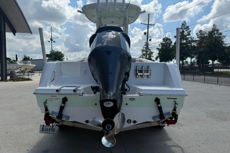 Slide: The Image of 2019 Sportsman 232 OE boat with powerful outboard motor, parked outdoors under cloudy sky. - 6