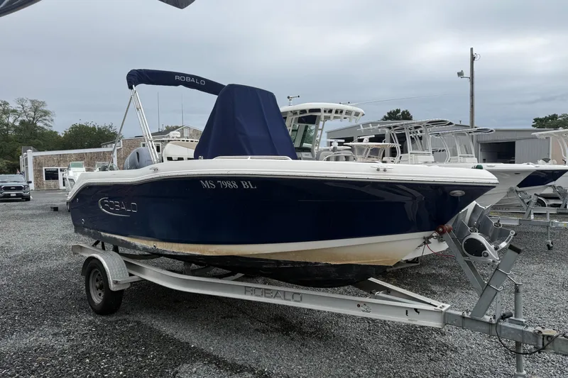 The Image of 2019 Robalo R180 Center Console boat on trailer, parked outdoors. - 0