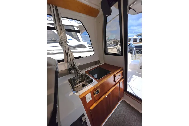 Slide: The Image of Interior view of 2020 Cutwater C-24 boat featuring a compact kitchen area. - 16
