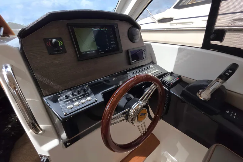 Slide: The Image of 2020 Cutwater C-24 helm with navigation controls and wooden steering wheel. - 19