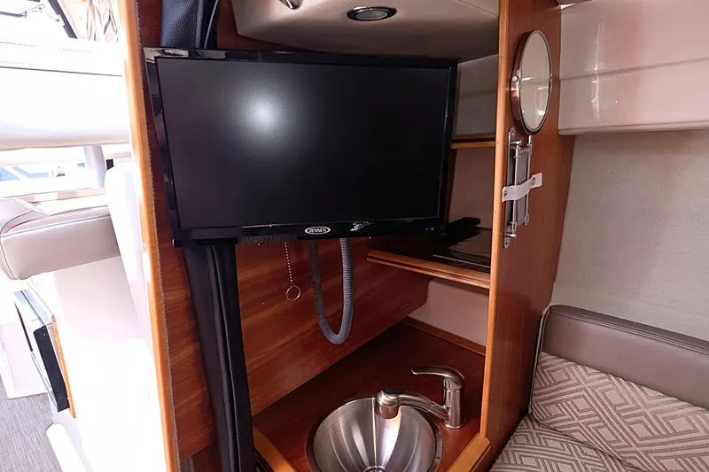 Slide: The Image of Interior of 2020 Cutwater C-24 boat featuring a TV, sink, and seating area. - 22