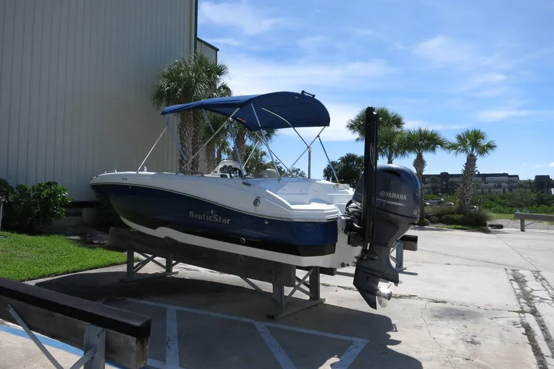 Slide: The Image of 2015 NauticStar 203SC Sport Deck boat with Yamaha motor, parked outdoors. - 10