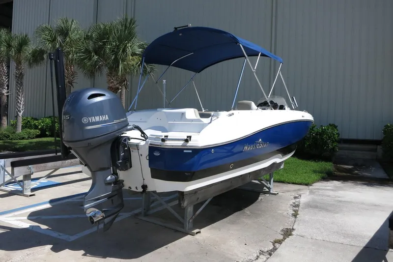Slide: The Image of 2015 NauticStar 203SC Sport Deck boat with Yamaha outboard motor, parked outdoors. - 12