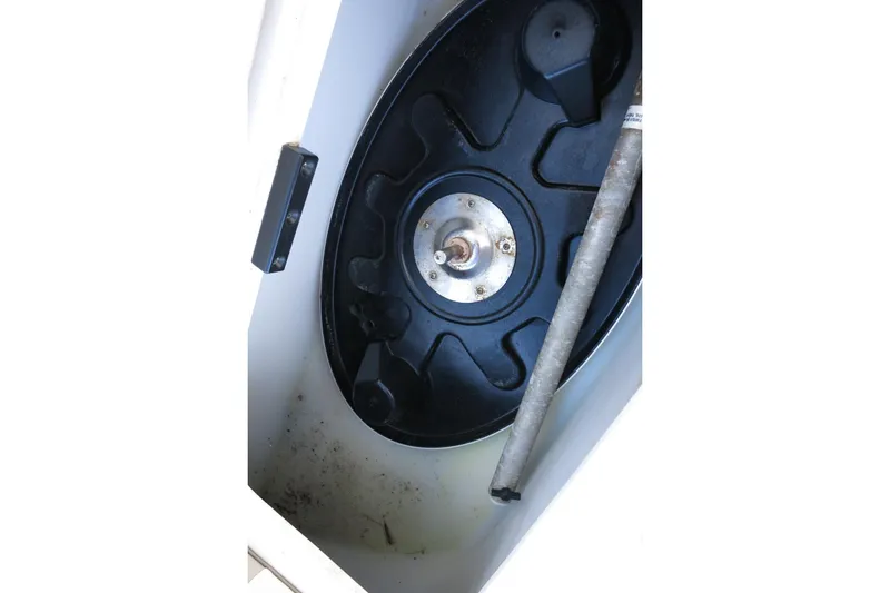 Slide: The Image of 2015 NauticStar 203SC Sport Deck storage compartment with black circular component. - 26