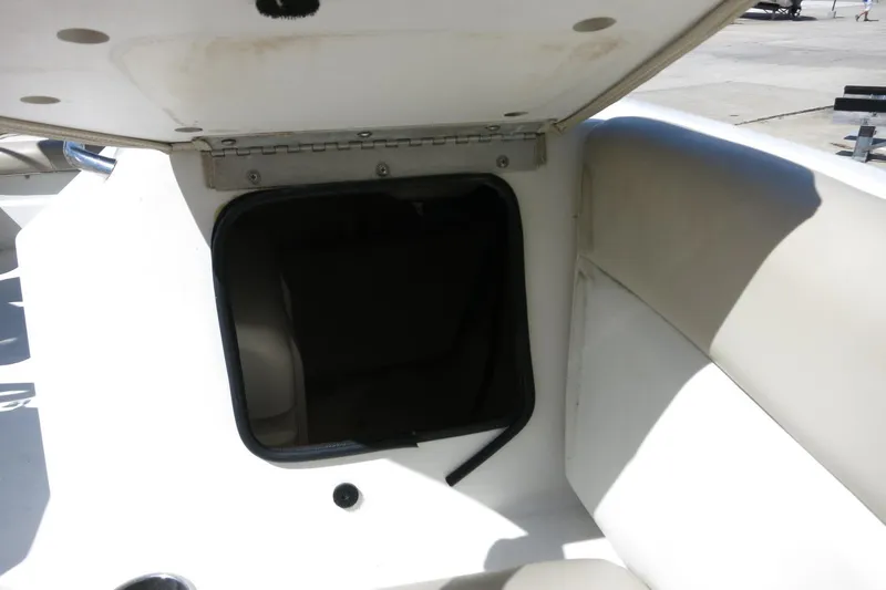 Slide: The Image of 2015 NauticStar 203SC Sport Deck boat storage compartment, open lid, white interior. - 28