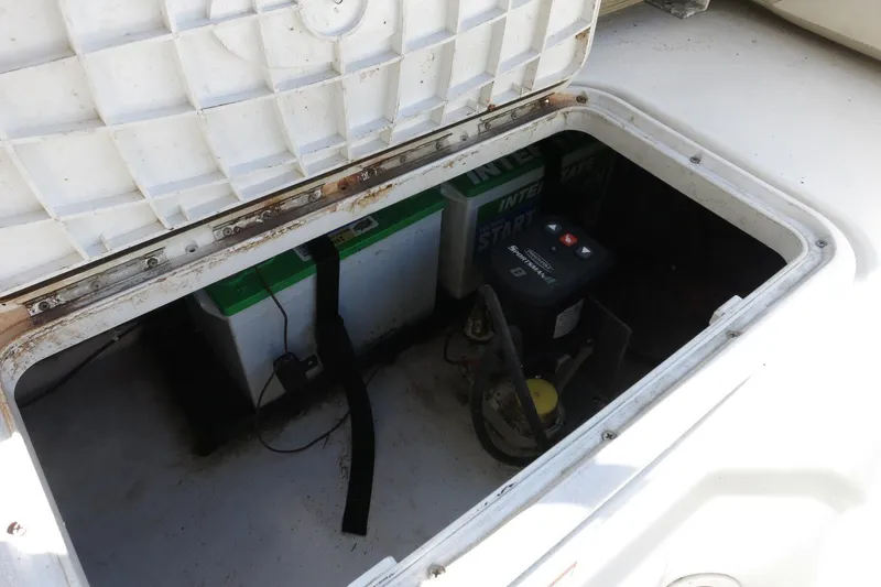 Slide: The Image of 2015 NauticStar 203SC Sport Deck battery compartment with visible battery and wiring. - 32