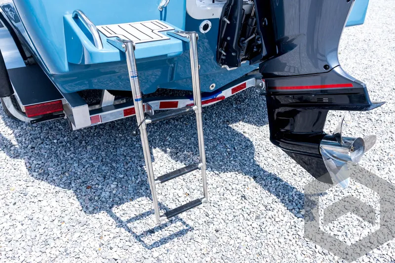 Slide: The Image of 2026 Tidewater 2110 Bay Max boat with ladder and motor on gravel surface. - 24