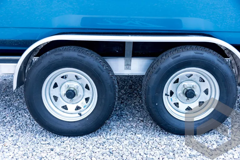 Slide: The Image of Trailer wheels of a 2026 Tidewater 2110 Bay Max boat on gravel. - 32