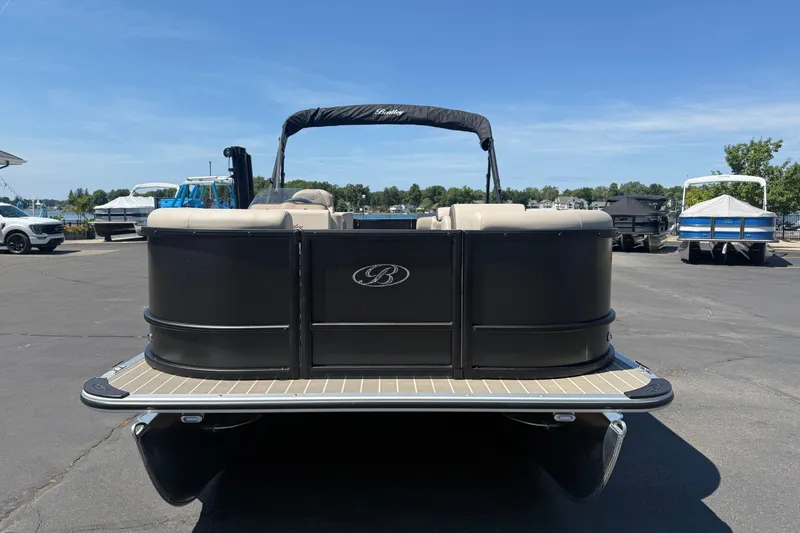 Slide: The Image of 2026 Bentley Pontoons LE 200 CW pontoon boat, black exterior, parked on asphalt under clear blue sky. - 2