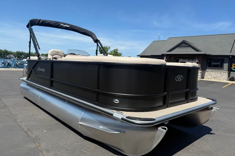 Slide: The Image of 2026 Bentley Pontoons LE 200 CW pontoon boat parked on pavement under clear blue sky. - 3