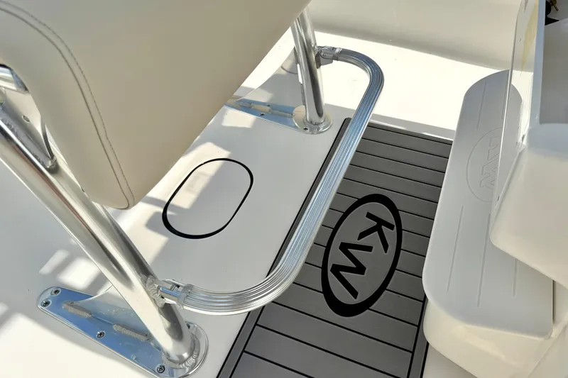 Slide: The Image of 2025 Key West 203 FS boat interior with sleek seating and KW logo on deck. - 19