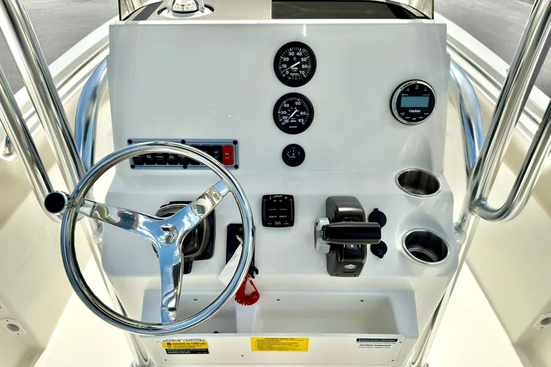 Slide: The Image of 2025 Key West 203 FS boat dashboard with steering wheel, gauges, and controls. - 2