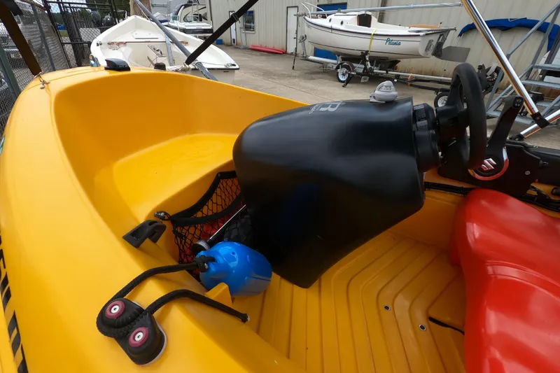 Slide: The Image of Yellow River Boats 290XR interior with steering wheel, 2022 model, docked near other boats. - 10