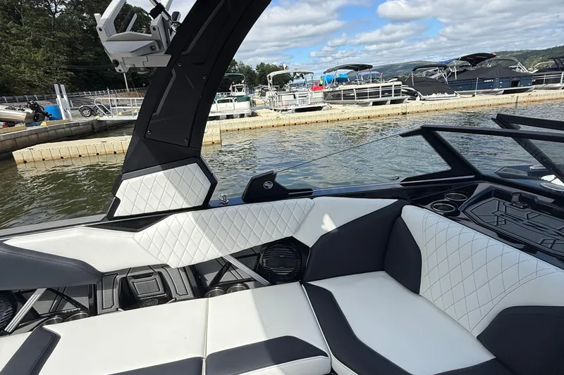 Slide: The Image of 2023 Tigé 24RZX boat interior with luxurious seating at a marina. - 14