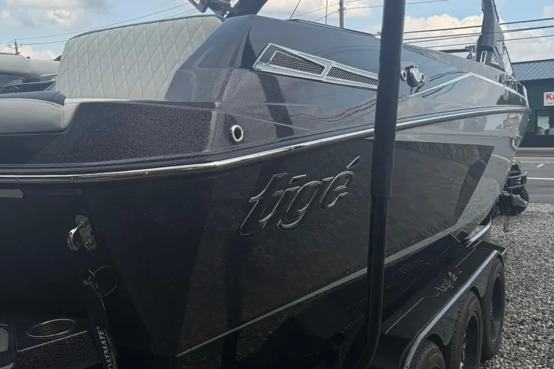 Slide: The Image of 2023 Tigé 24RZX boat, sleek black exterior, parked on a trailer. - 2