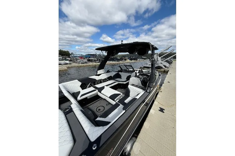 Slide: The Image of 2023 Tigé 24RZX boat docked, featuring sleek interior and modern design under a cloudy sky. - 5