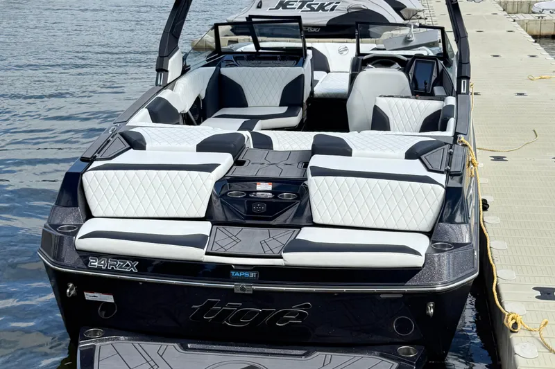 Slide: The Image of 2023 Tigé 24RZX boat with luxurious seating, docked by the water. - 6