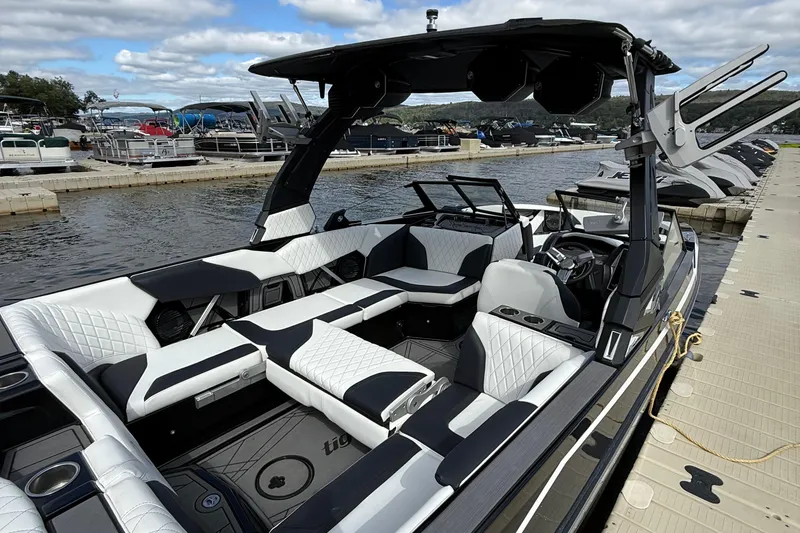 Slide: The Image of 2023 Tigé 24RZX boat with luxurious seating at a marina dock. - 7