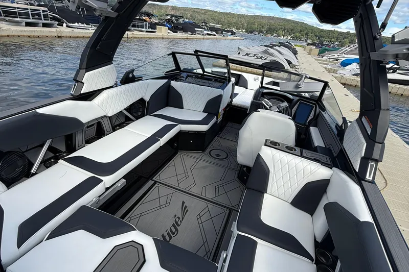 Slide: The Image of 2023 Tigé 24RZX boat interior with modern seating and sleek design at a marina. - 8