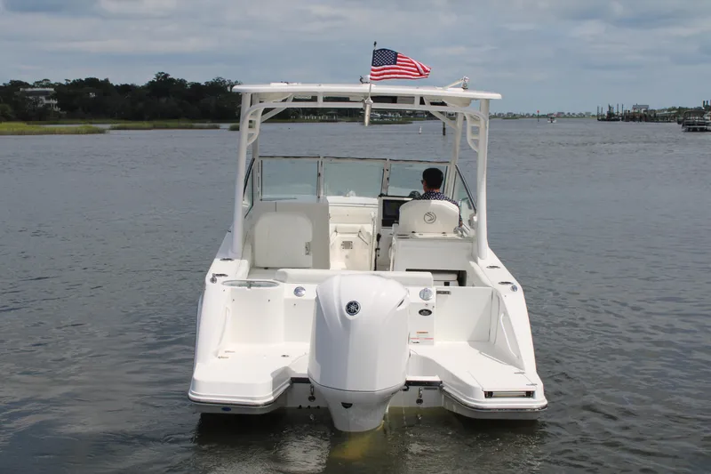 Slide: The Image of 2020 Edgewater 230 CX boat on water, rear view with American flag. - 16