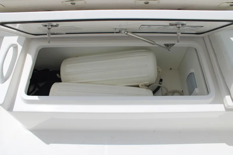 Slide: The Image of Open storage compartment on 2020 Edgewater 230 CX boat with fenders inside. - 23