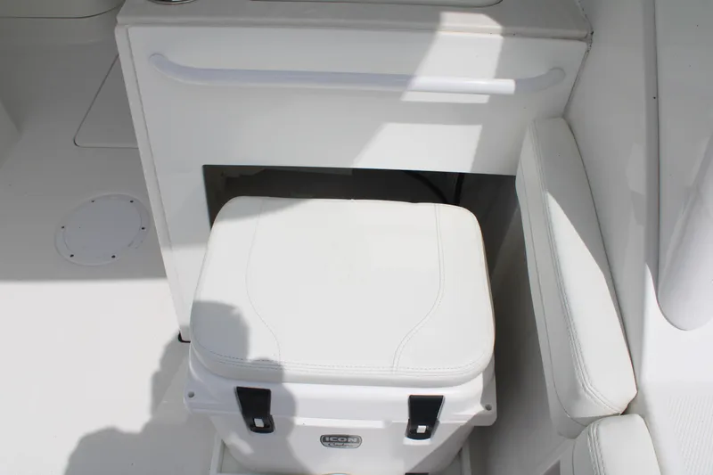 Slide: The Image of Edgewater 230 CX 2020 boat interior with white cushioned seating and storage area. - 28