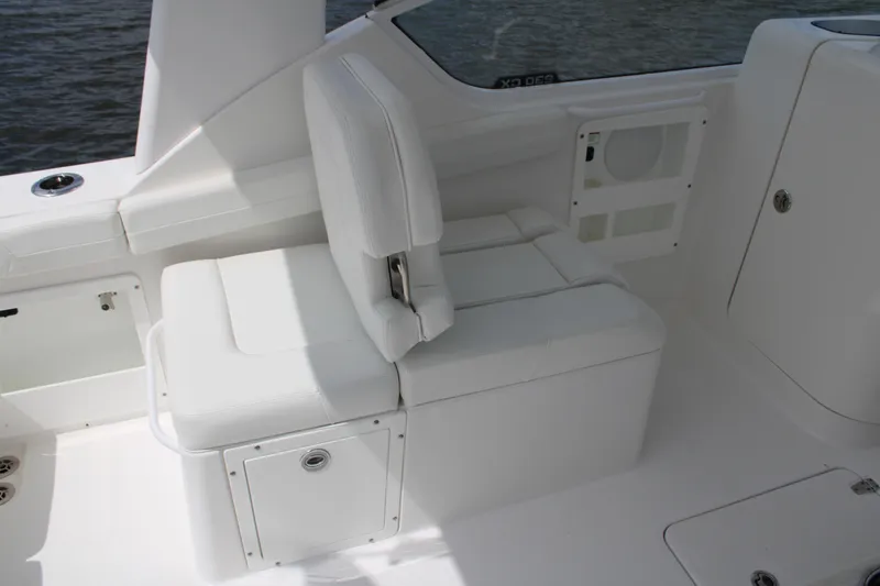 Slide: The Image of 2020 Edgewater 230 CX boat interior with white seating and storage compartments. - 34