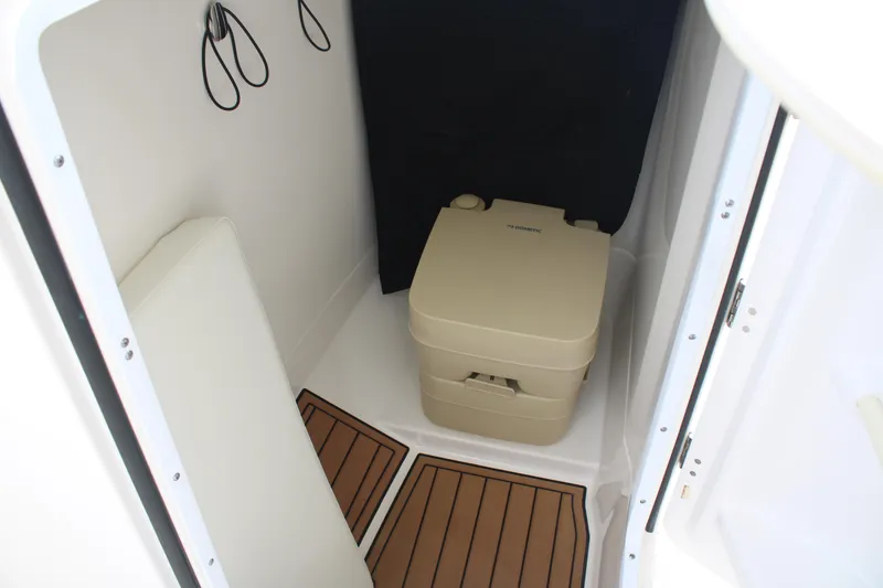 Slide: The Image of 2020 Edgewater 230 CX boat interior with portable toilet and wooden flooring. - 36
