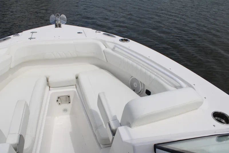 Slide: The Image of 2020 Edgewater 230 CX boat with white seating, on calm water. - 44