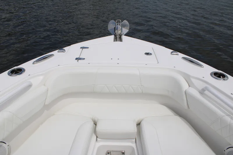 Slide: The Image of 2020 Edgewater 230 CX boat interior with white seating, on calm water. - 45