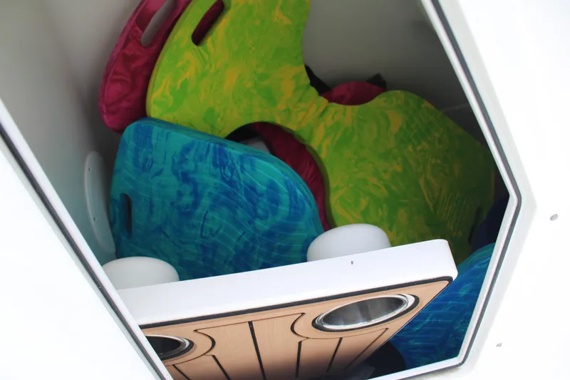 Slide: The Image of Colorful storage compartment in 2020 Edgewater 230 CX boat, featuring vibrant kneeboards. - 54
