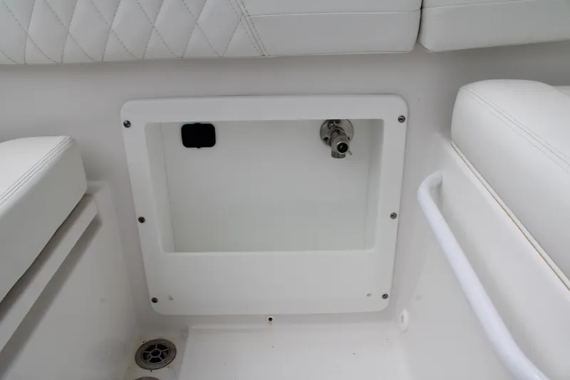 Slide: The Image of Edgewater 230 CX 2020 boat interior storage compartment with white cushioned seating. - 57