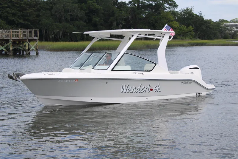 Slide: The Image of 2020 Edgewater 230 CX boat named "Wanderlust" cruising on a calm river. - 6