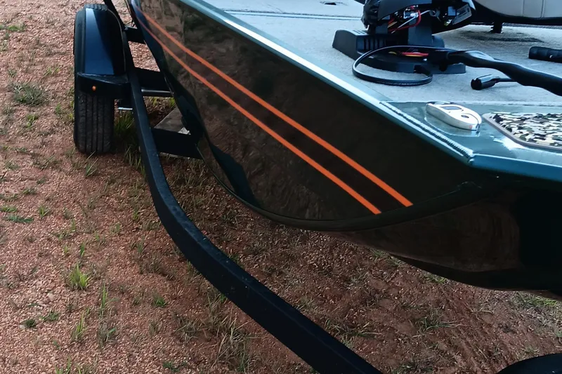 Slide: The Image of 2026 Tracker Bass Tracker Classic Limited boat on trailer, featuring sleek design and orange stripes. - 12