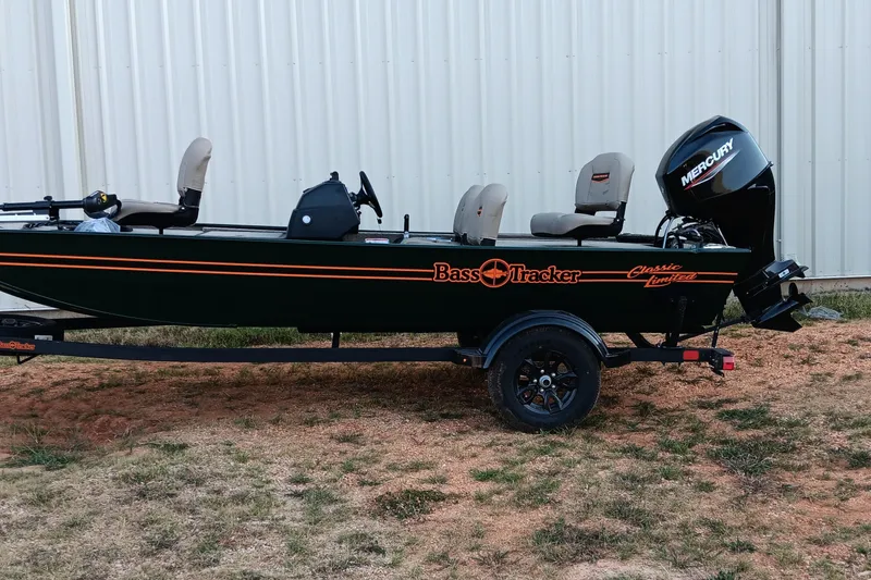 Slide: The Image of 2026 Tracker Bass Tracker Classic Limited boat with Mercury engine, parked on grass. - 4