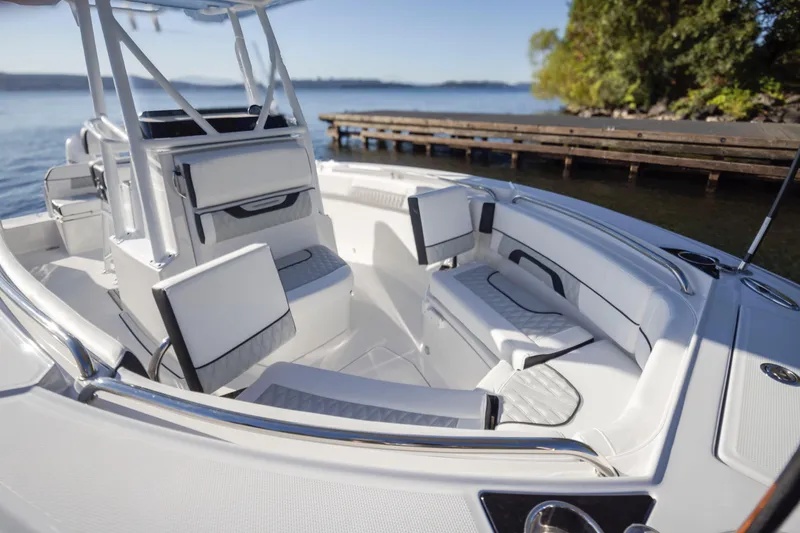 Slide: The Image of 2024 Blackfin 222 CC boat interior with luxurious seating, docked by a serene lake. - 14