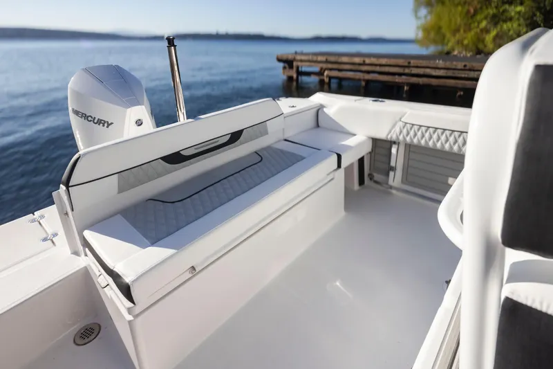 Slide: The Image of 2024 Blackfin 222 CC boat interior with Mercury engine, docked by serene waters. - 19