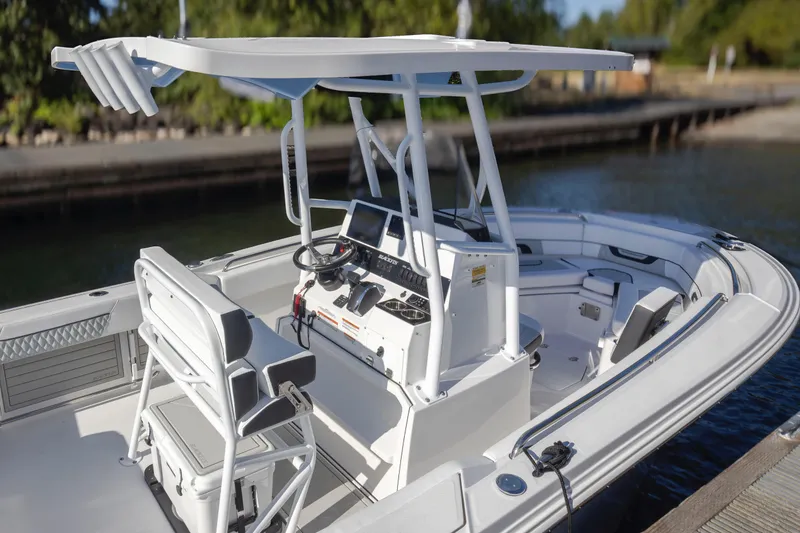 Slide: The Image of 2024 Blackfin 222 CC boat with modern console and seating, docked by the water. - 20