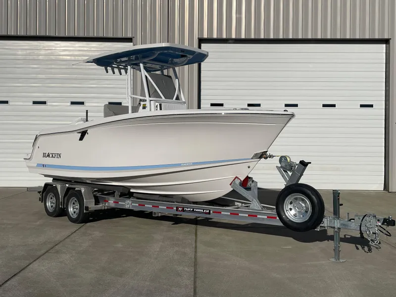 Slide: The Image of 2024 Blackfin 222 CC boat on trailer, parked in front of large garage doors. - 31