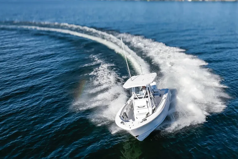 Slide: The Image of 2024 Blackfin 222 CC boat speeding on open water, creating a dynamic wake. - 4