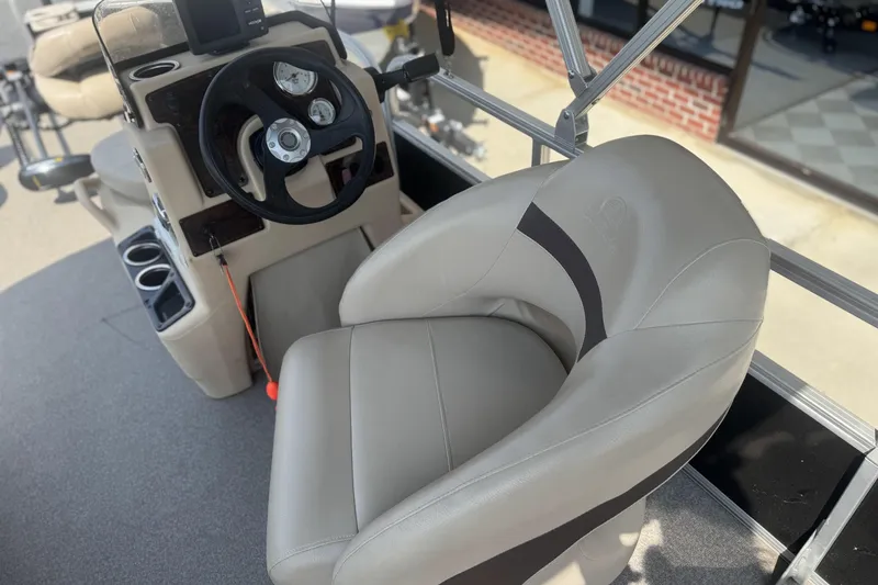 Slide: The Image of 2017 Sun Tracker Bass Buggy 18 DLX boat interior with steering wheel and comfortable seating. - 19