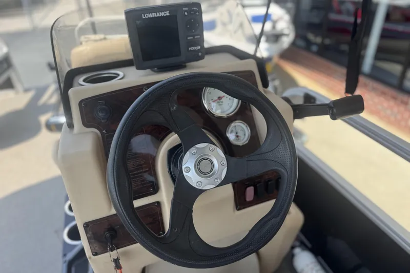 Slide: The Image of 2017 Sun Tracker Bass Buggy 18 DLX dashboard with steering wheel and Lowrance fish finder. - 20