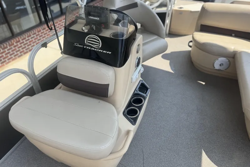 Slide: The Image of 2017 Sun Tracker Bass Buggy 18 DLX interior with beige seating and control panel. - 21