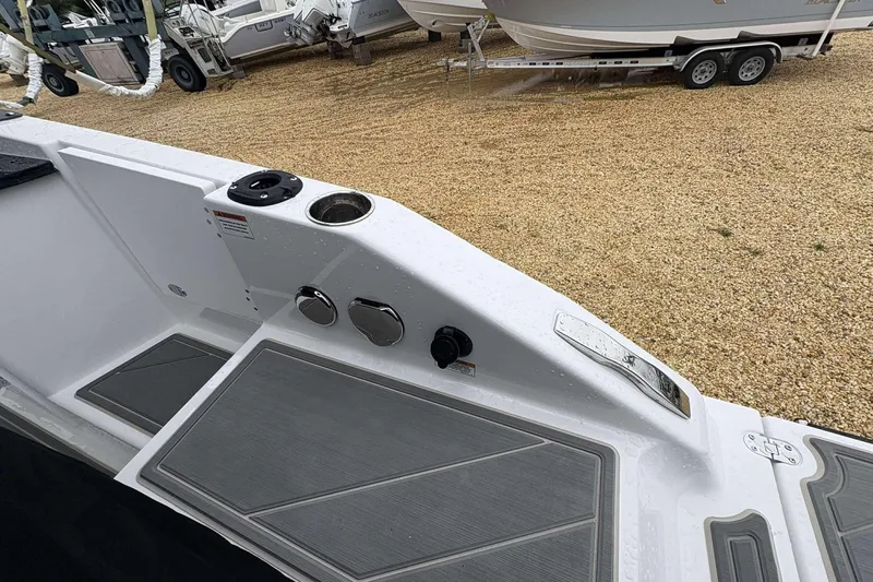 Slide: The Image of 2026 Monterey 27 Elite boat deck with cup holder and control panel, parked on gravel. - 10